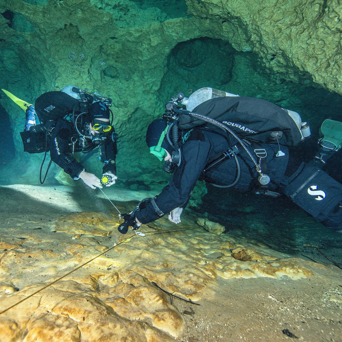 Two divers exploring underwater cave.
