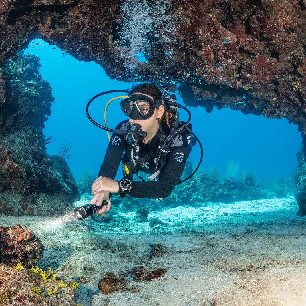 Scuba diver explores underwater cave with flashlight (SP_0510310X_G3_971271)