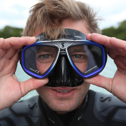 Scuba diver holding Scubapro mask, SP_24157002, looking at camera.