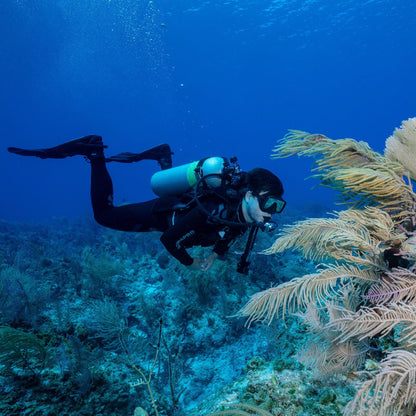 Scuba diver with frameless mask exploring coral reef.