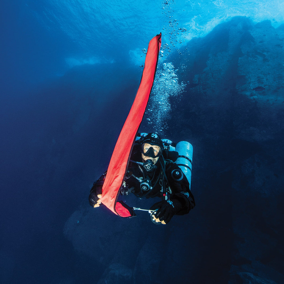 Diver deploying surface marker buoy (SP_40312001) underwater.